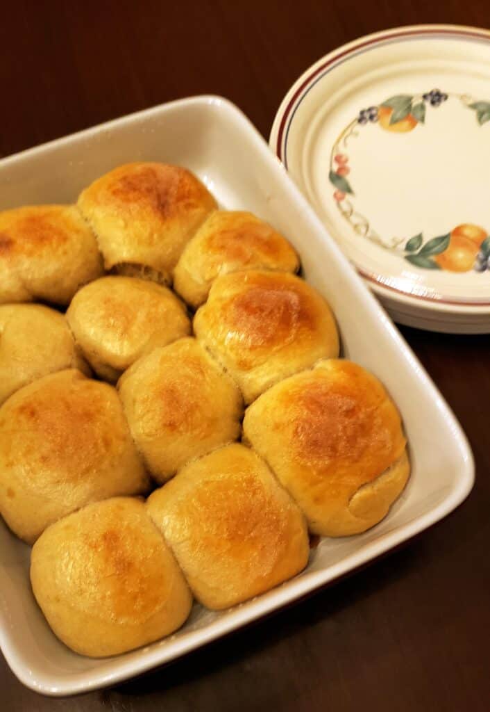 a pan of sourdough rolls nestled beside dinner plates