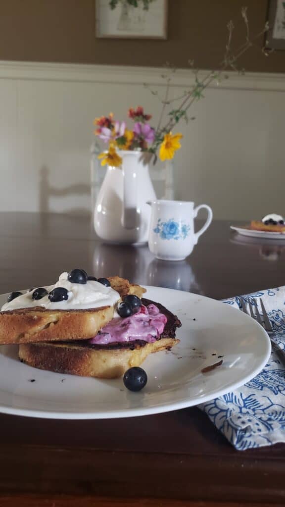 blueberry and cream French toast on a set breakfast table