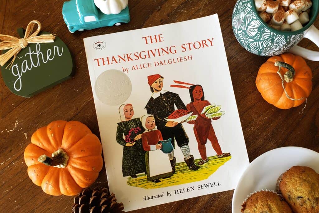 The Thanksgiving Story by Alice Dalgliesh surrounded by fall decor, fall book club