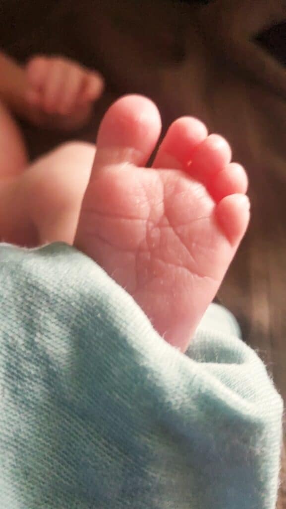 a baby's foot sticking out of a blanket